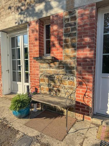 a bench sitting in front of a brick building at La Maison de Cécile in Cahan