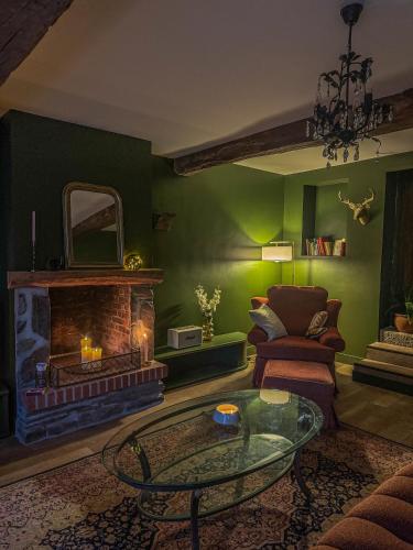 a living room with a fireplace and a glass table at La Maison de Cécile in Cahan