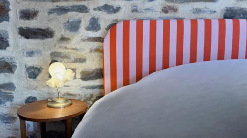 a lamp on a table next to a bed at La Maison de Cécile in Cahan
