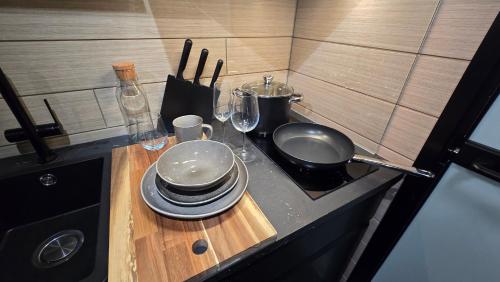a kitchen counter with a sink and plates and glasses at Koskenselän Lomakylä in Puumala