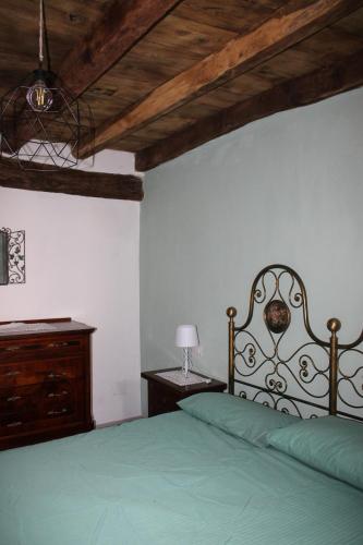 a bedroom with a green bed and a wooden ceiling at PRIMA DEL CIELO - appartamento MONTI in Esino Lario