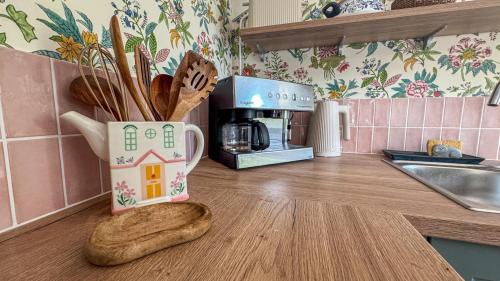 a kitchen counter with a cup with a house on it at La Maison de Cécile in Cahan