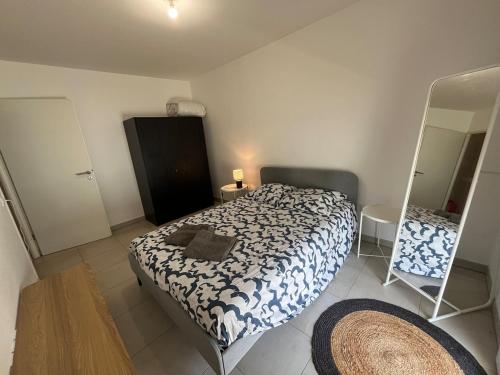 une petite chambre avec un lit et un miroir dans l'établissement Joli T2 Terrasse Parking privé Confort, à Montpellier