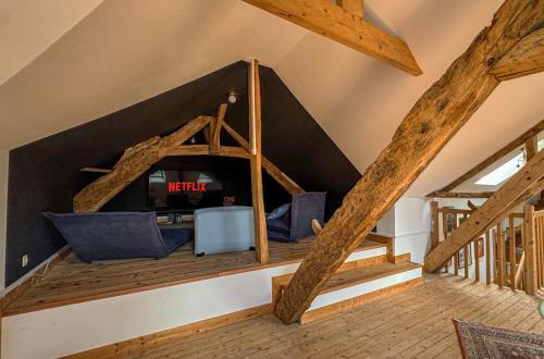a living room with a roof with wooden beams at La Maison de Cécile in Cahan