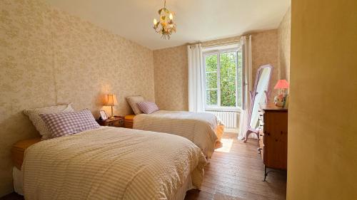 a bedroom with two beds and a window at La Maison de Cécile in Cahan