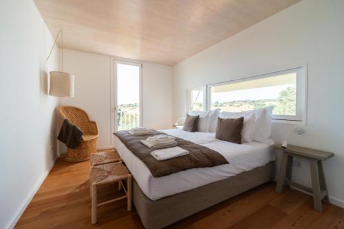a bedroom with a large bed and a window at Monte das Casolas in Grândola