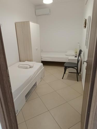 a small room with a bed and a chair at Niko's apartments 1 in Elafonisos