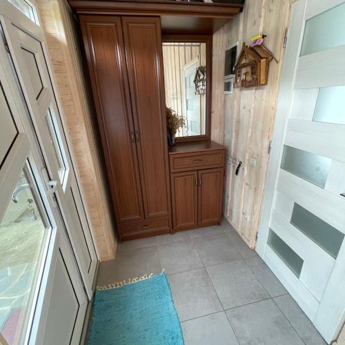a hallway with a wooden door and a blue rug at Едем in Verkhovyna