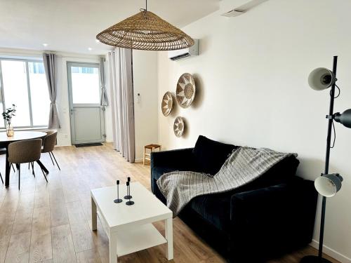 a living room with a black couch and a table at Loft Moderne climatisé centre ville in Valence