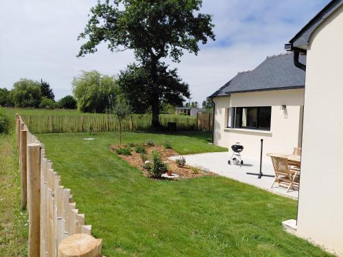 a yard with a fence next to a house at Saint-Cast-Le-Guildo in Saint-Cast-le-Guildo