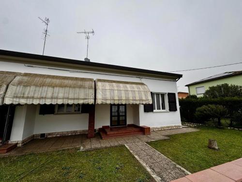 a white house with a porch and a grass yard at Moto-apartment in Boccaleone