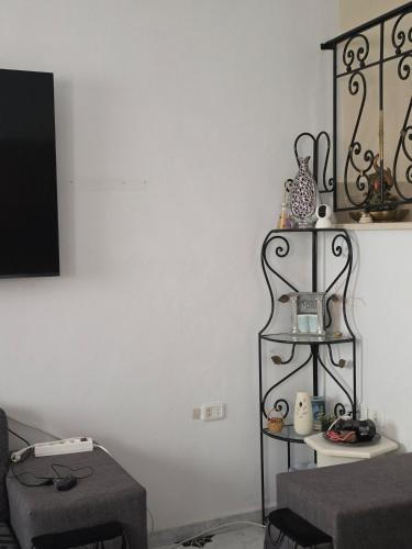 a living room with a tv and a shelf at Merveilleuse Villa à Borj El Ras in Mahdia