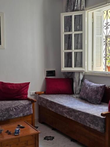 a bedroom with two beds and a window at Merveilleuse Villa à Borj El Ras in Mahdia