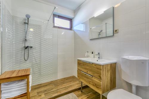 un bagno con wc, lavandino e doccia di Levendula Apartman a Hegykő