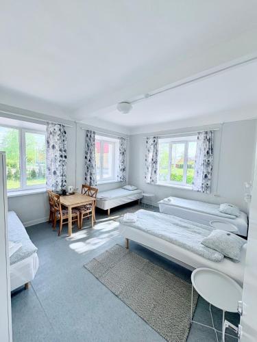 a white room with two beds and a table at Endla Hostel ja Apartamendid in Haapsalu