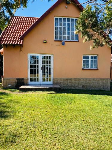 a house with a white door and a grass yard at The Qs guest suite in Vosburg