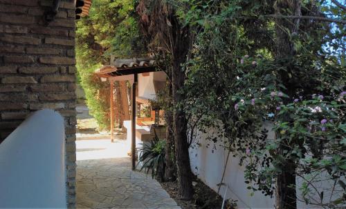 a white fence and a tree next to a building at Gianni's village home in Aegina Town