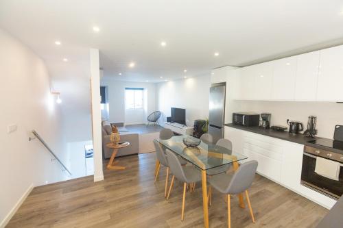a kitchen and dining room with a table and chairs at Vista do Farol in Lagoa