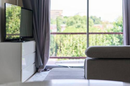 a living room with a couch and a large window at Appartement 3 pièces Nice-Ouest in Nice