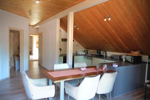 a kitchen with a wooden ceiling and a wooden table and chairs at Ferienwohnung Andermann in Neukirchen