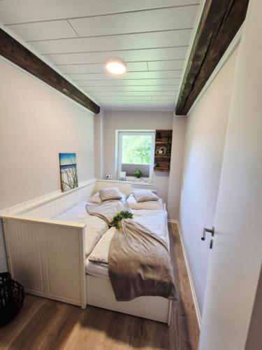 a bedroom with two beds and a window at Ferienwohnung Hein sien Huus Rodenäs Nordfriesland in Rodenäs