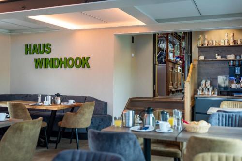 a restaurant with tables and chairs and a sign that reads hawks winds window at Haus Windhook in Dierhagen