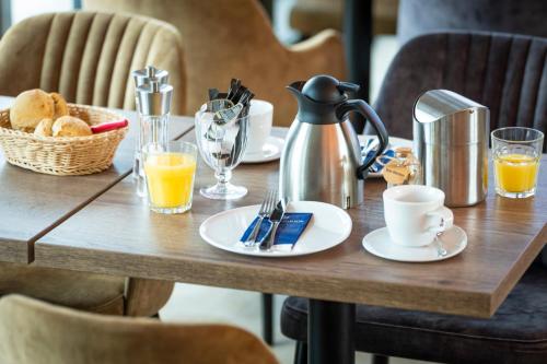 a table with a tea kettle and a basket of orange juice at Haus Windhook in Dierhagen