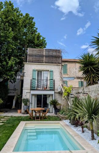 une maison avec une piscine devant une maison dans l'établissement Charmant studio avec jardin, à Avignon