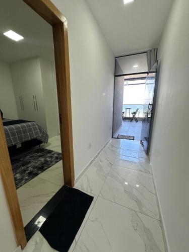 a room with a hallway with a mirror and a bedroom at Pousada orla Mar in Maricá