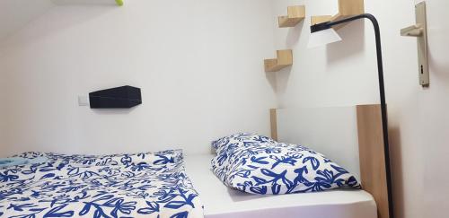 a bed with blue and white sheets and a lamp at Zusy in Orebić