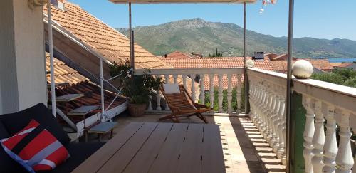a balcony with a wooden table and a view of a mountain at Zusy in Orebić