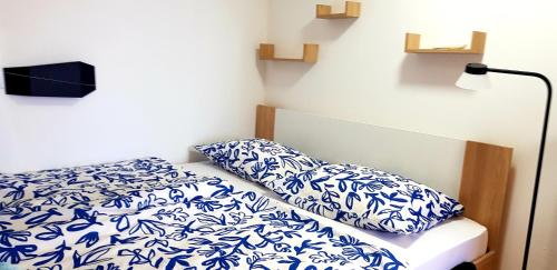 a bed with blue and white sheets and pillows at Zusy in Orebić