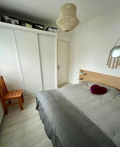 une chambre avec un lit avec un oreiller rouge dessus dans l'établissement La Bergeronnette, à Ondres