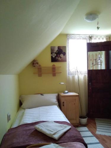 a bedroom with a bed and a window at Pensiunea Lali Madaras Ciuc in Mădăras