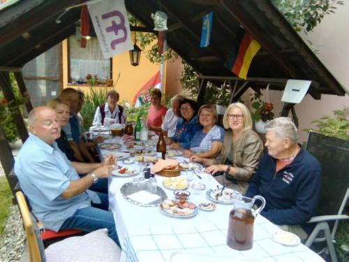 a group of people sitting at a table eating at Pensiunea Lali Madaras Ciuc in Mădăras