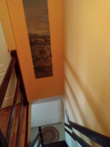 a stairway with a painting on the wall next to a staircase at Pensiunea Lali Madaras Ciuc in Mădăras