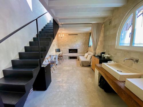 a bathroom with a staircase with a sink and a living room at Via Paradiso 32 in Feltre