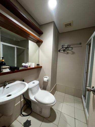 a bathroom with a toilet and a sink at Studio unit inside IT Park Wifi & Netflix in Cebu City