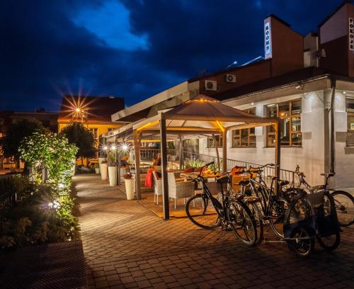 a group of bikes parked under an umbrella at night at Pod Wzgórzem Bed & Breakfast in Frombork