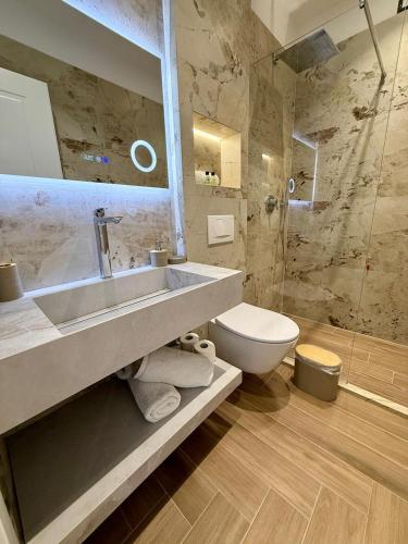 a bathroom with a sink and a toilet at Gent's Inn Luxury in Durrës