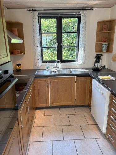 a kitchen with a sink and a window at Feriebolig smukt beliggende i vandkanten in Munkebo