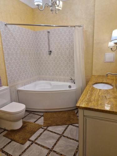 a bathroom with a tub and a toilet and a sink at Затишна квартира на Майдані Незалежності in Kyiv