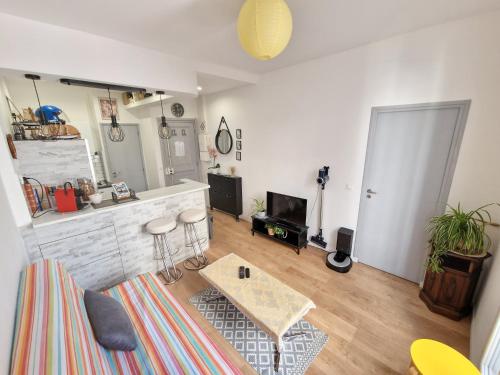 un salon avec une table et une cuisine dans l'établissement Un magnifique appartement a Paris Jourdain, à Paris