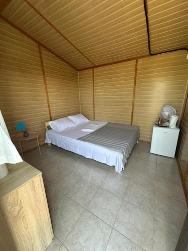 a bedroom with a bed in a wooden wall at Oaza de Corbu in Corbu