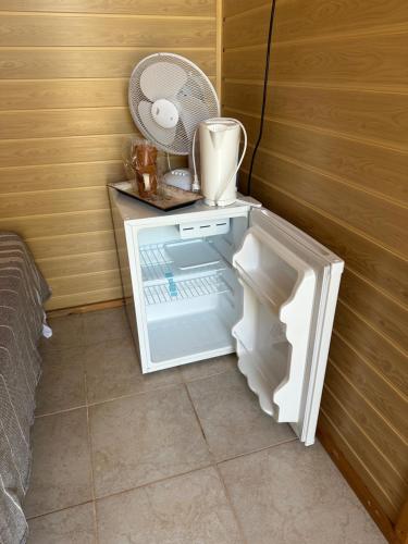 a small refrigerator with its door open in a room at Oaza de Corbu in Corbu