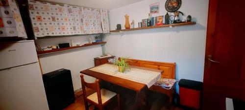 a small kitchen with a table and a refrigerator at La Dimora di Beatrice in Santa Brigida