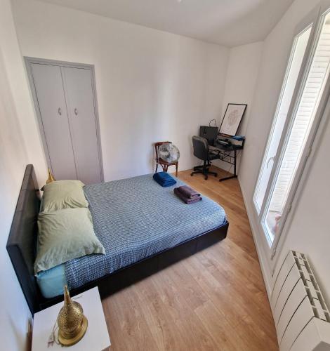 une chambre avec un lit et un bureau avec une chaise dans l'établissement Un magnifique appartement a Paris Jourdain, à Paris