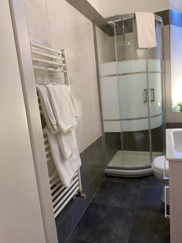 bagno con doccia, lavandino e asciugamani di Garibaldi Island Apartment in the heart of Milan a Milano