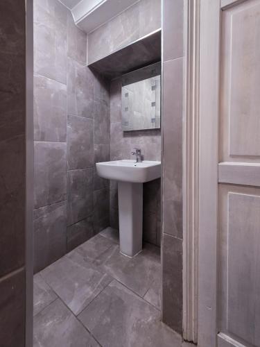 un baño con lavabo y espejo en The Courtyard Lodge, en Hitchin