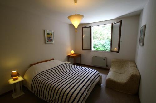 une chambre avec un lit, une chaise et une fenêtre dans l'établissement Spacieuse maison familiale entre pins et océan jusqu'à 10 personnes, à Tosse